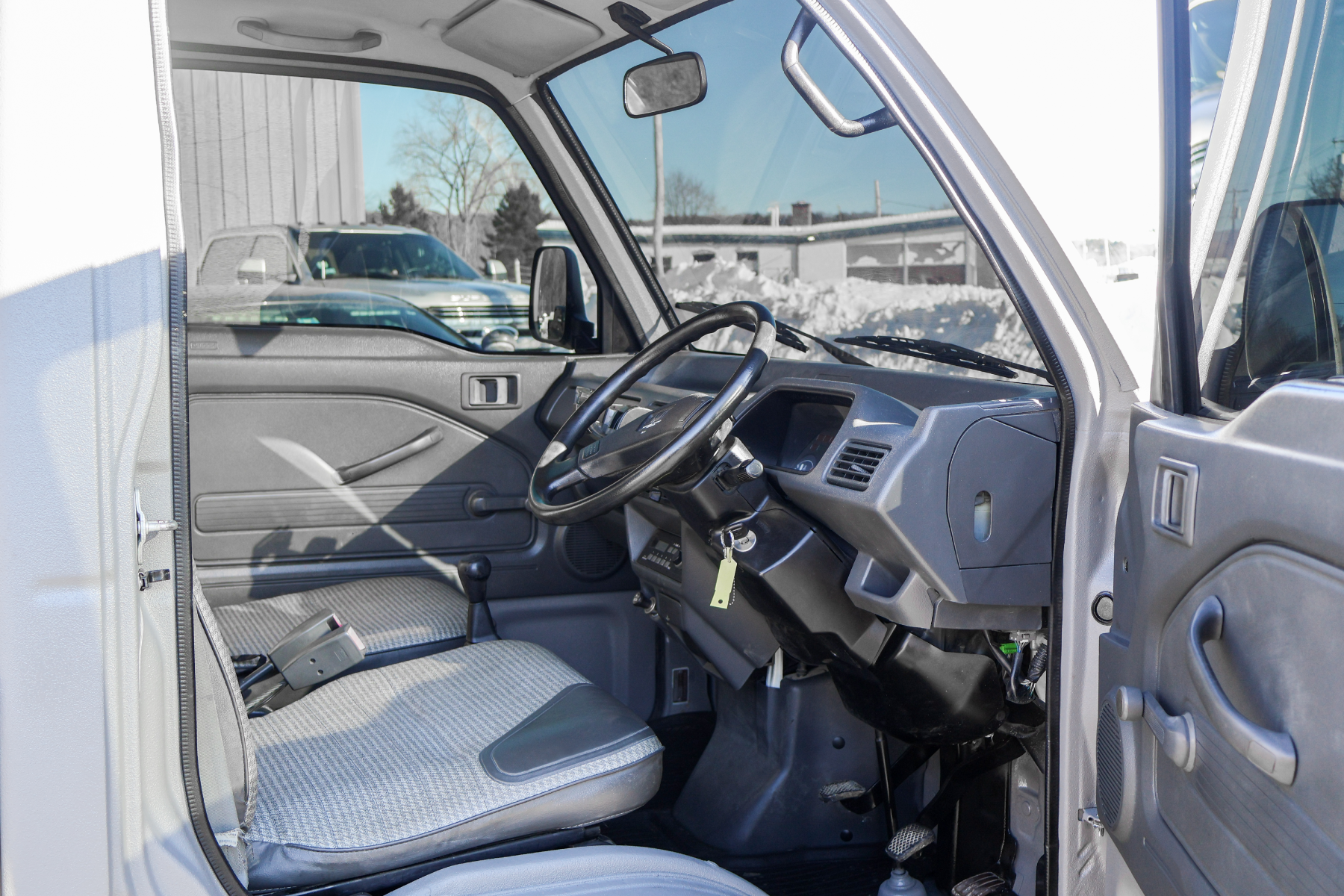 Interior of a vehicle with a clear view of the dashboard and steering wheel.