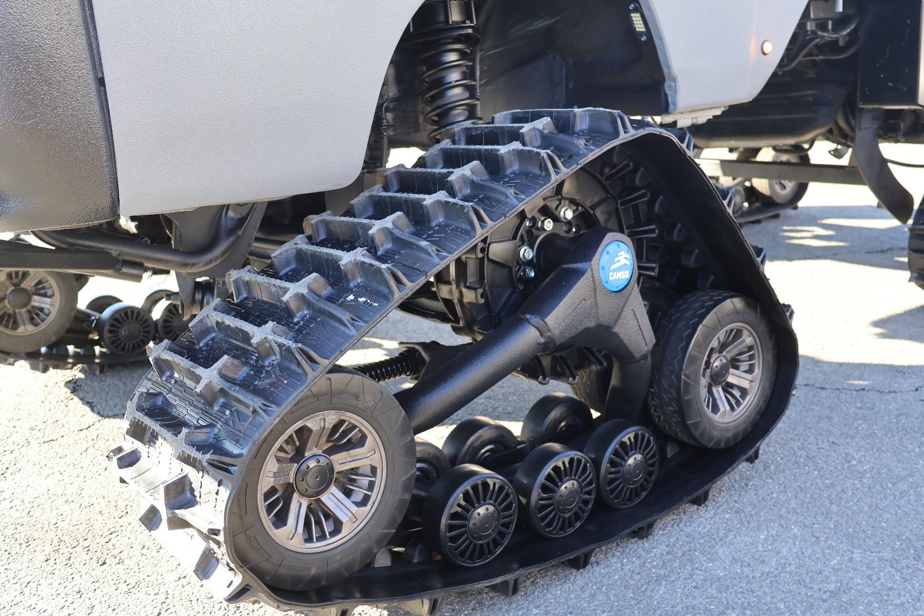 Specialized vehicle tracks attached to a mini truck on a paved surface
