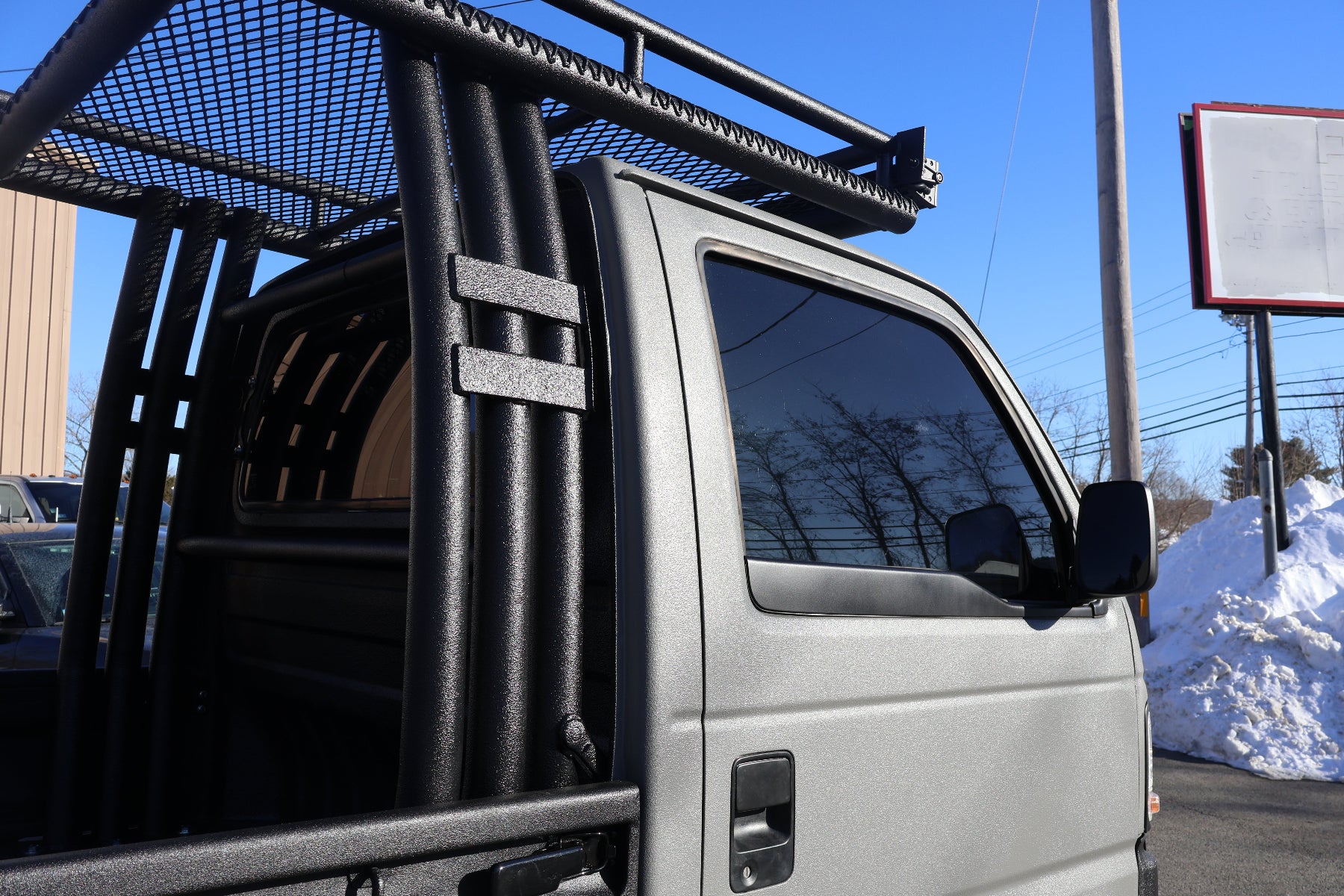 mini truck with a black metal rack on a clear day