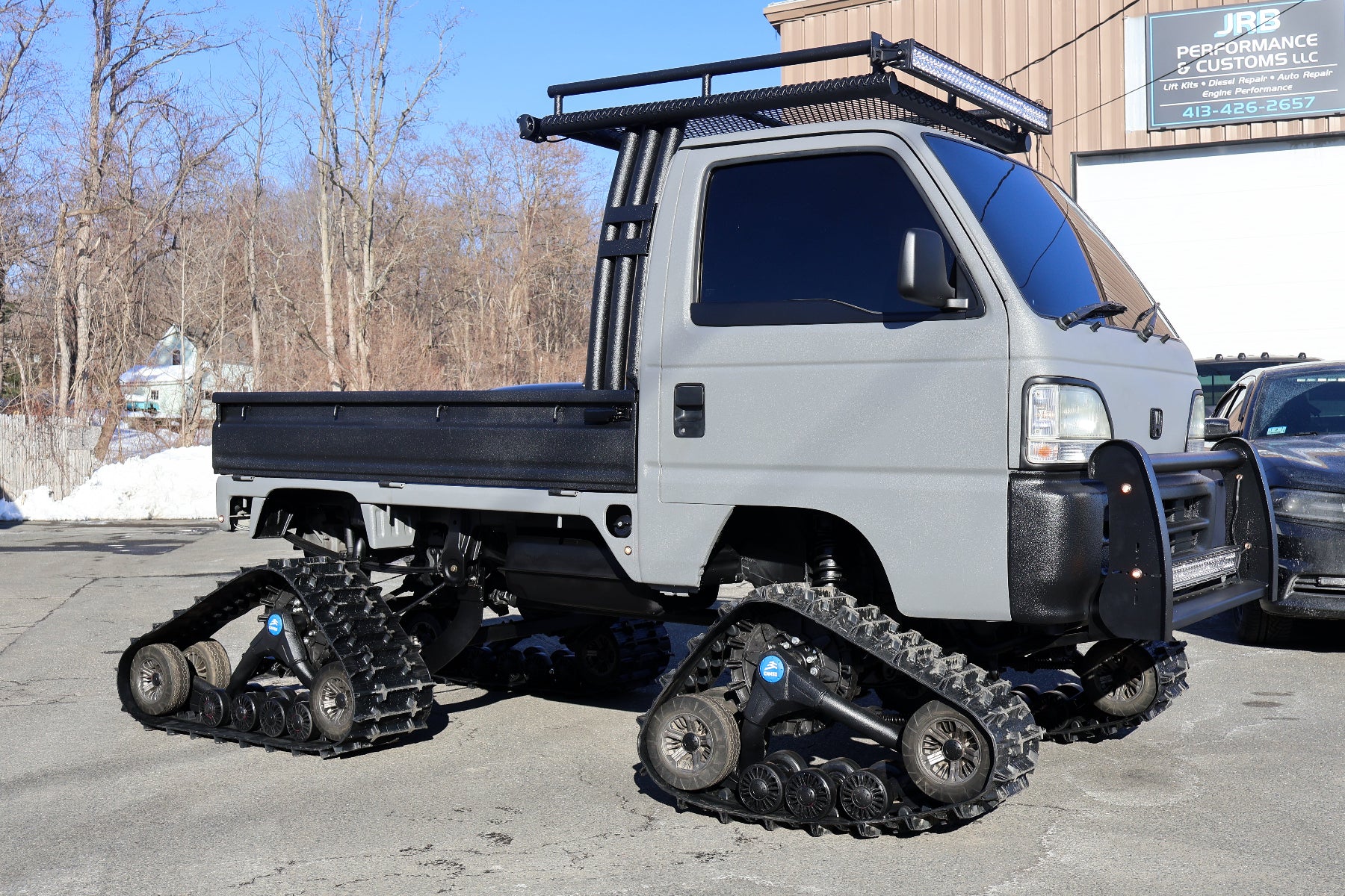 mini truck modified with tracks in a parking lot