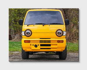 JRB7 custom yellow mini truck canvas on a dirt road with greenery in the background