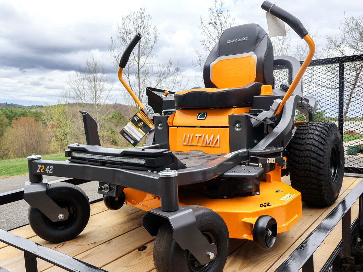 yellow and black cub cadet ultima zero-turn lawn mower on a trailer with a scenic background