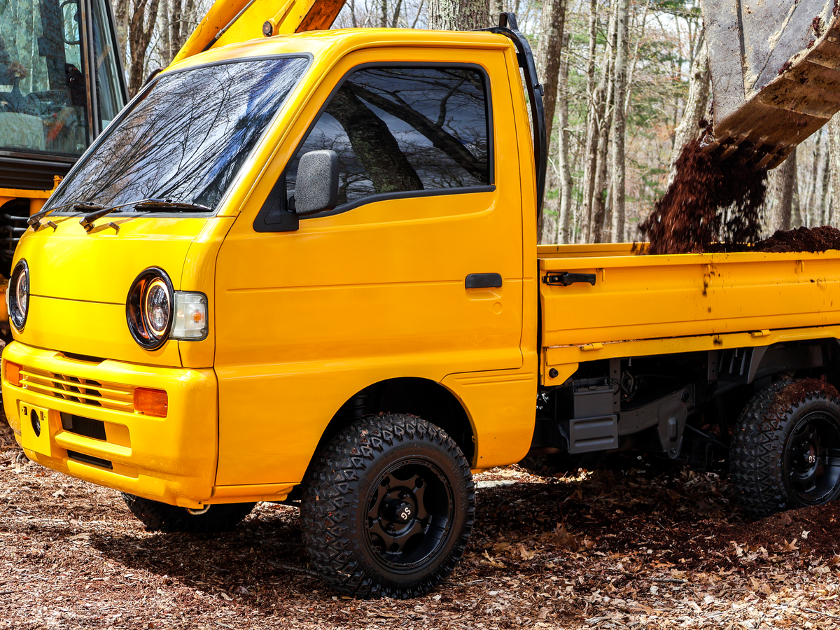 yellow suzuki carry side shot loading dump bed