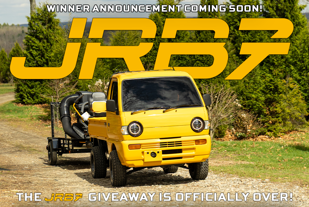 Yellow truck with a trailer on a dirt road, surrounded by trees, with text about JRB7 giveaway has ended, winner announcement coming soon.