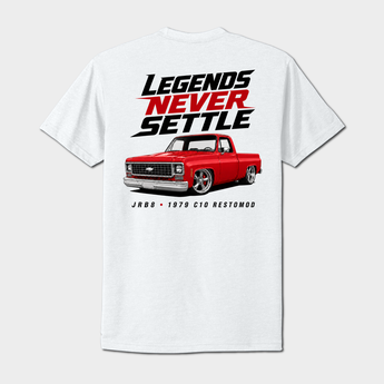 A white short-sleeve t-shirt with a graphic print on the front. The graphic features the text 'LEGENDS NEVER SETTLE' in black and red, above an illustration of a red pickup truck, with 'JRB8 - 1979 C10 RESTOMOD' printed below.