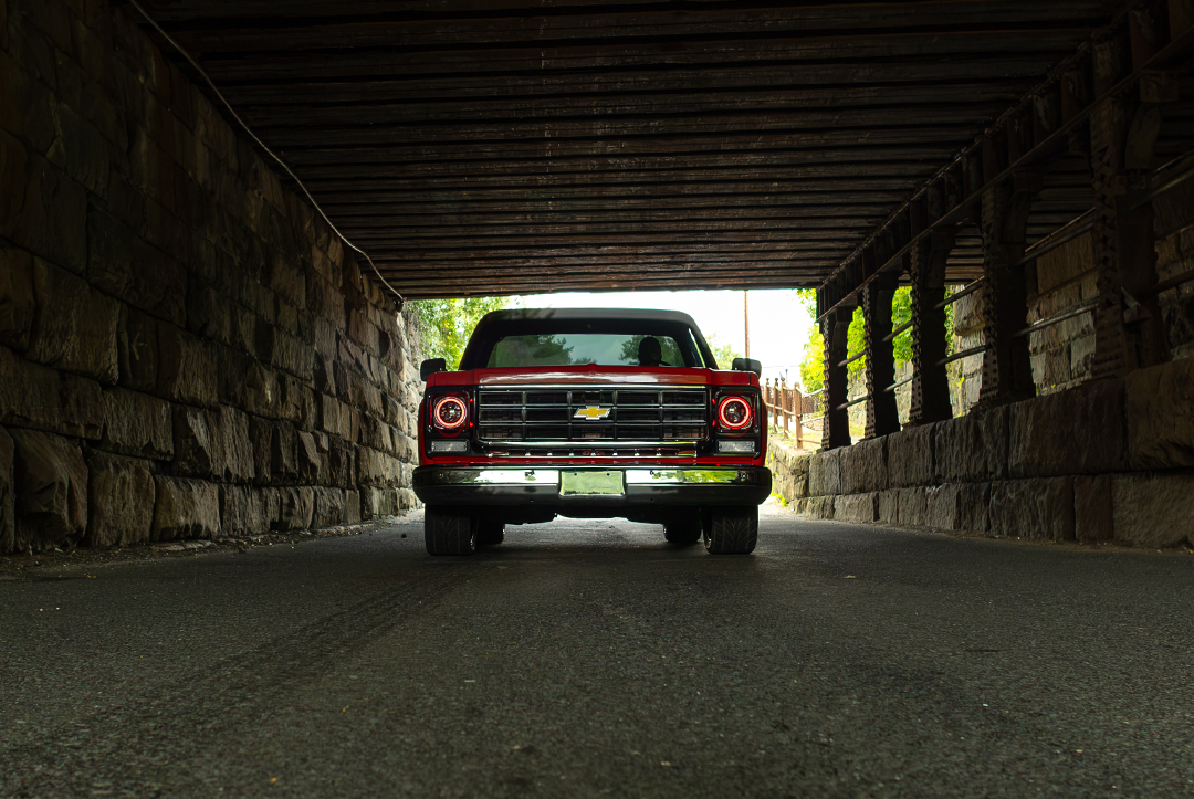 Red C10 pickup under bridge