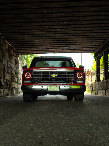 Red C10 pickup under bridge
