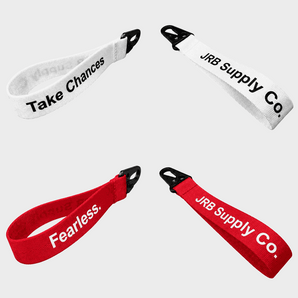 Two white lanyards with 'Take Chances' text and two red lanyards with 'JRB Supply Co.' text on a white background.
