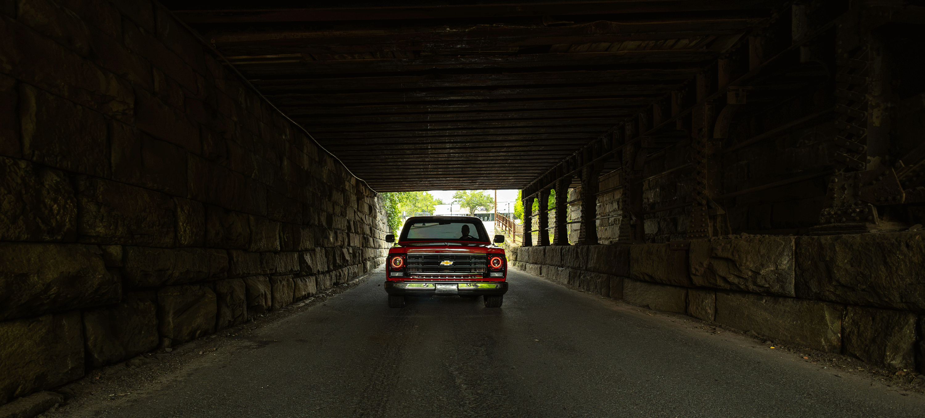 Red C10 pickup under bridge