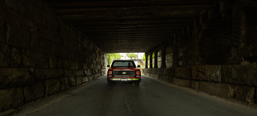 Red C10 pickup under bridge